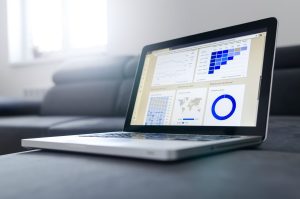 Laptop showing a conversion tracking analytics dashboard with user sessions, device and country data for South African businesses.